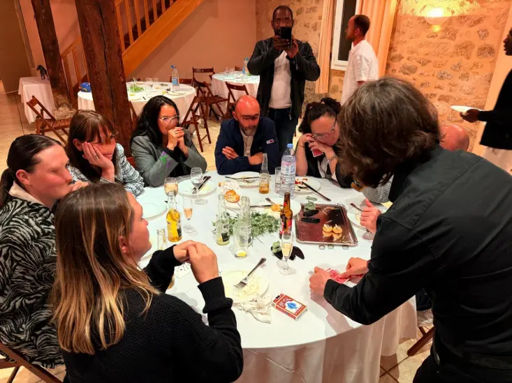 Josh grand magicien réalisant un tour de magie à une table de restaurant